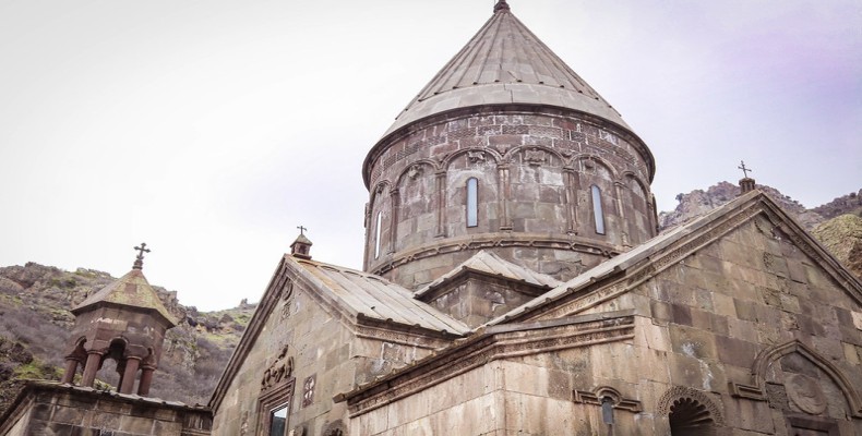 نمای نزدیک کلیسای گغارت ارمنستان با جزئیات گنبد و معماری سنگی