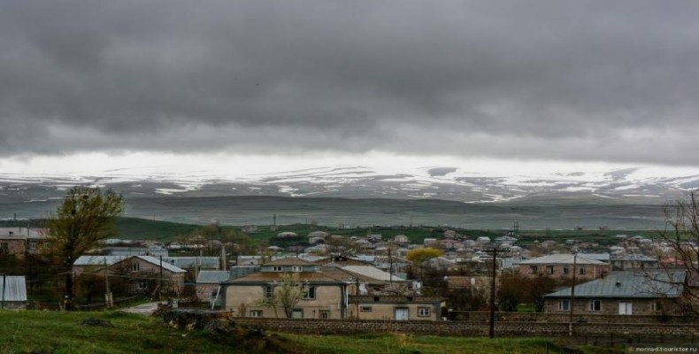 نمایی از روستای نرکین گتاشن در نزدیکی دریاچه سوان با چشمانداز کوهستانی و آسمان ابری