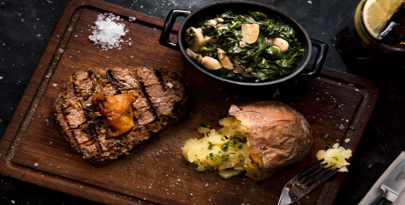 استیک گریل‌شده با سیب‌زمینی پخته و مخلفات سبزیجات 