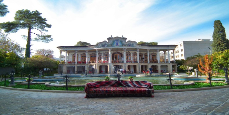 نمای عمارت شاپوری شیراز با حوض پنجپر و محوطه باغ در روز