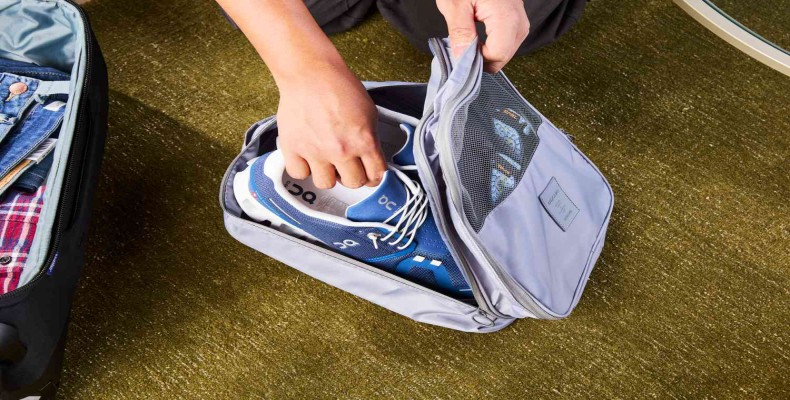 قرار دادن کفشها در کیف مخصوص برای جلوگیری از کثیف شدن چمدان