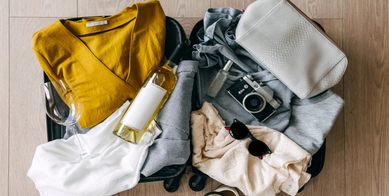 چمدان باز با لباسها و وسایل سفر چیدهشده داخل آن