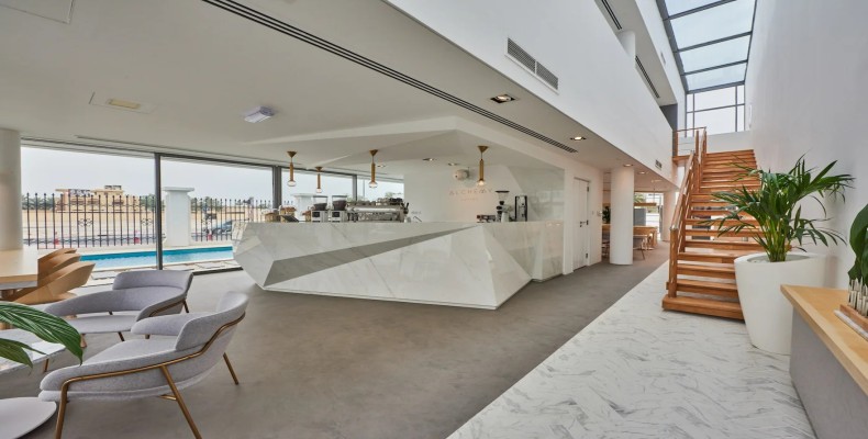 طراحی مینیمال و سفید کافه آلکمی دبی با تراس مشرف به استخر