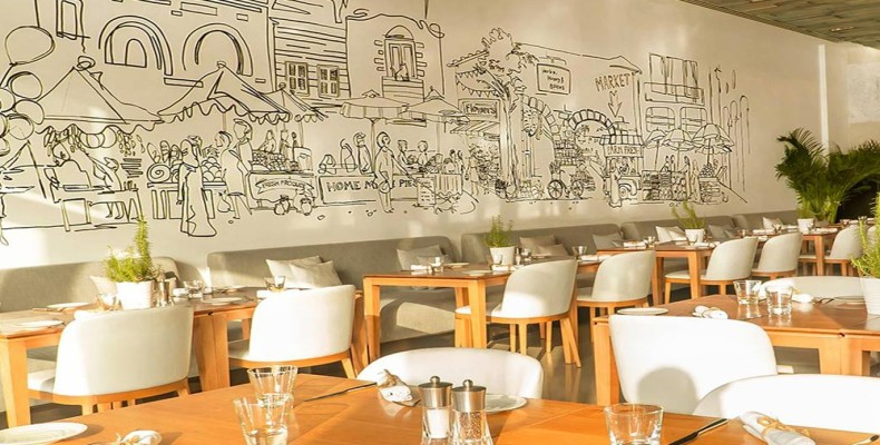 کافه نیکی (Café Nikki) در دبی؛ فضای باز کنار استخر و میزهای چوبی برای صبحانه در دبی