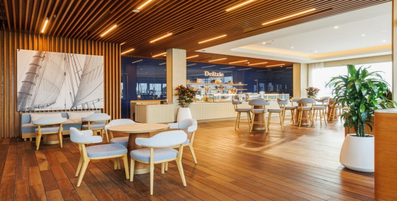 فضای داخلی کافه دلیزی گورمت در دبی مارینا با منظره دریا و چیدمان چوبی مدرن