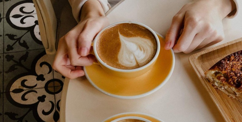 نجان قهوه و شیرینی روی میز در کافه ایست وست دبی با فضای مینیمال و آرام