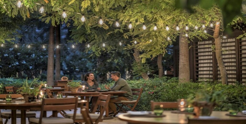 فضای باز و آرام رستوران Folia دبی با چیدمان چوبی و نور ملایم؛ از رستوران‌های گیاهی معروف در دبی