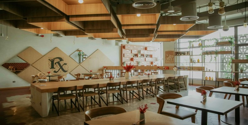 نمای داخلی کافه آر ایکس در جمیرا با سقف چوبی هندسی و میزهای بلند اشتراکی