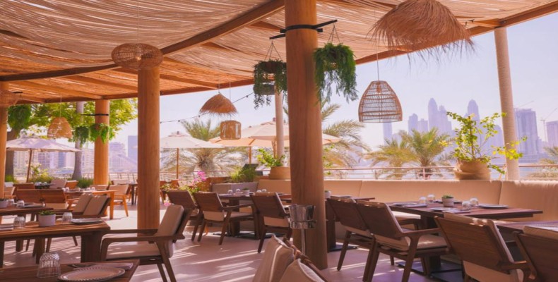 رستوران اولا (Ula Dubai) در ساحل پالم جمیرا؛ چشمانداز دریا و میزهای چوبی برای صرف صبحانه