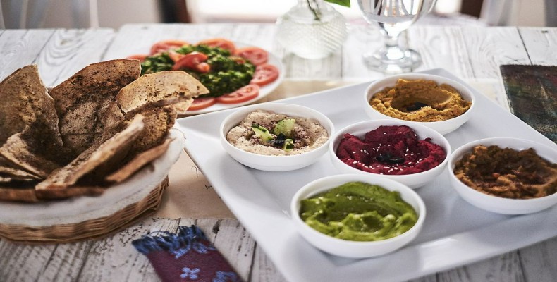 فضای صمیمی و هنری کافه رستوران XVA دبی با دکور سفید و چراغ‌های حصیری؛ از رستوران‌های گیاهی و وگان دبی