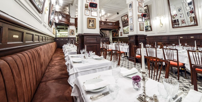 فضای سفید و کلاسیک رستوران 1924 استانبول با میزهای منظم و عکسهای قدیمی روی دیوار