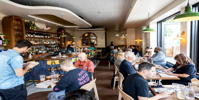 فضای دوستانه و شلوغ رستوران Batifole تورنتو با مشتریان در حال صرف غذا