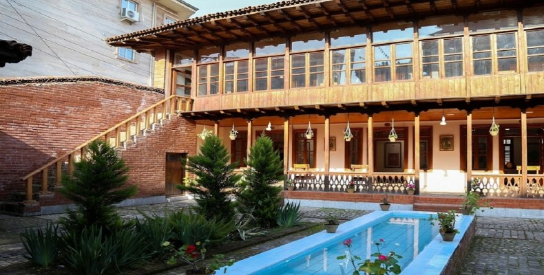 نمایی از خانه تاریخی میرزا کوچک‌خان جنگلی در رشت، با معماری چوبی و حیاط سنتی گیلانی