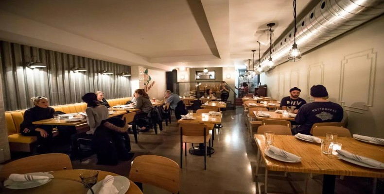 فضای گرم و پرانرژی رستوران Patois تورنتو با میزهای چوبی و حالوهوای دوستانه