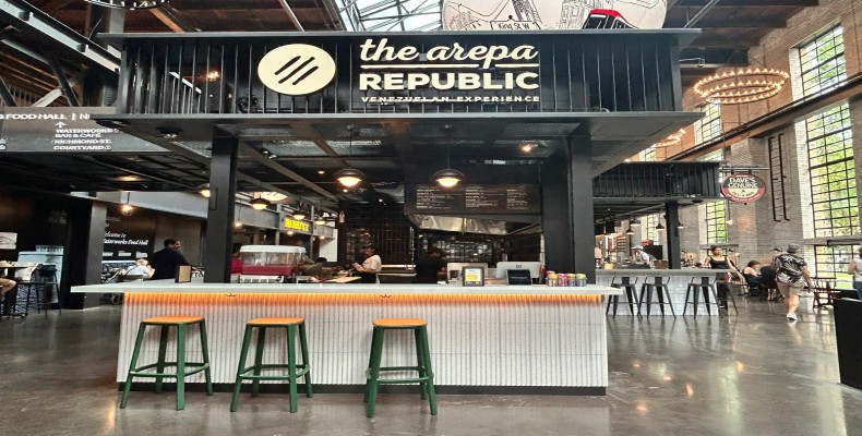 نمای داخلی رستوران The Arepa Republic تورنتو با طراحی مدرن و میزهای چوبی