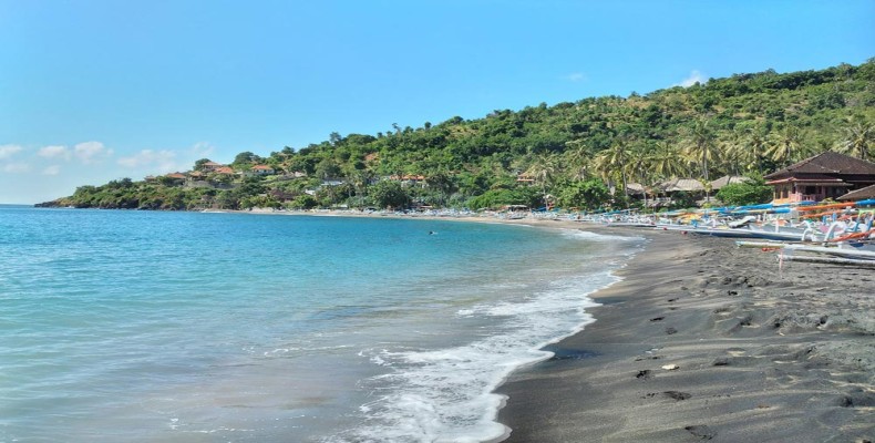 ساحل لیپا در بالی با شنهای تیره و آب شفاف