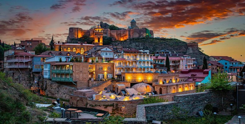 نمای غروب شهر تفلیس با خانههای رنگارنگ و قلعه ناریکالا – گرجستان از ارزانترین مقاصد سفر خارجی برای ایرانیان